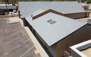 Professional crew performing commercial roofing in Phoenix on a large business complex.